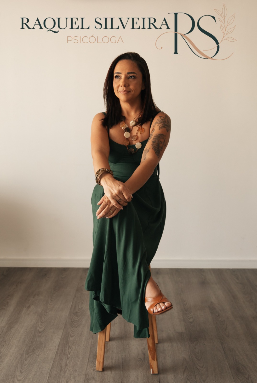 Raquel Silveira - Psicóloga sentada em um banco, vestindo verde, com fundo bege e logo RS